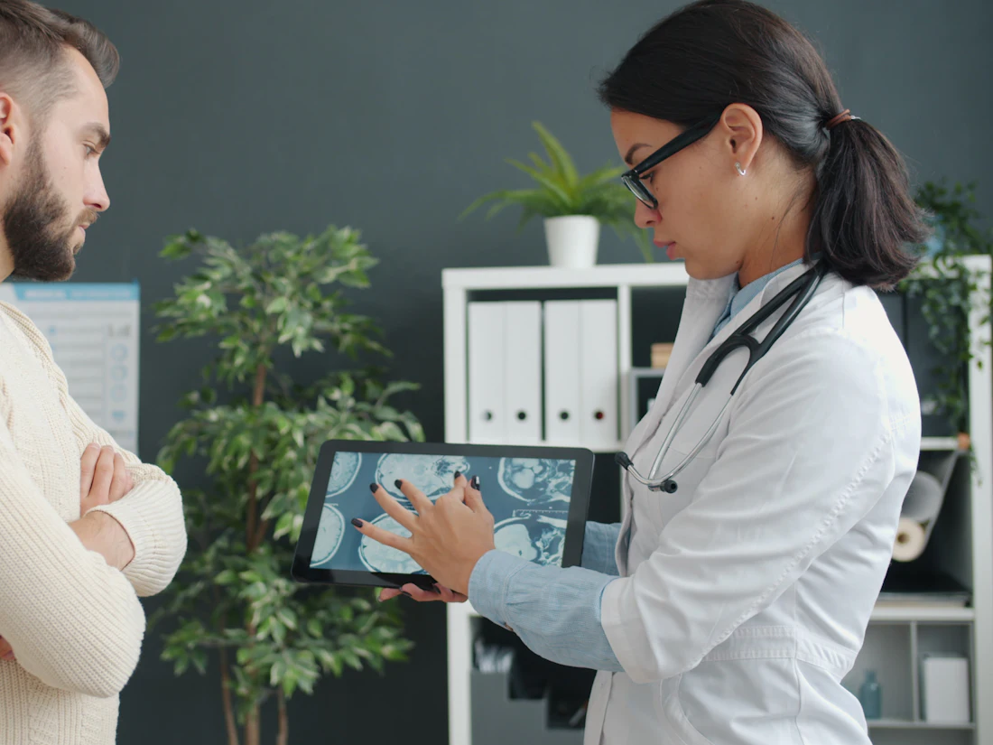A doctor showing a patient a scan on a tablet
